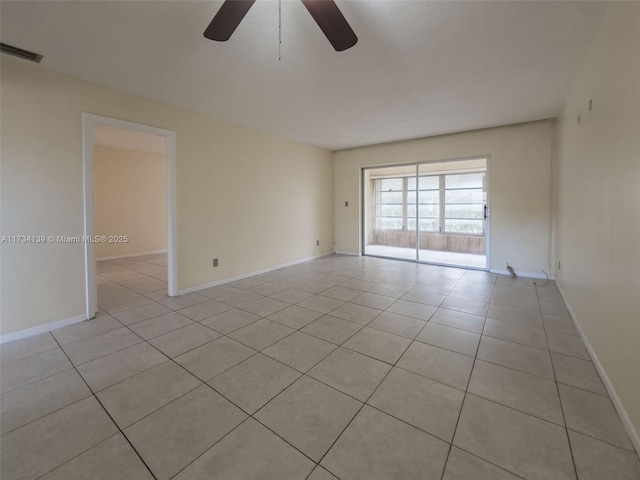 tiled spare room featuring ceiling fan