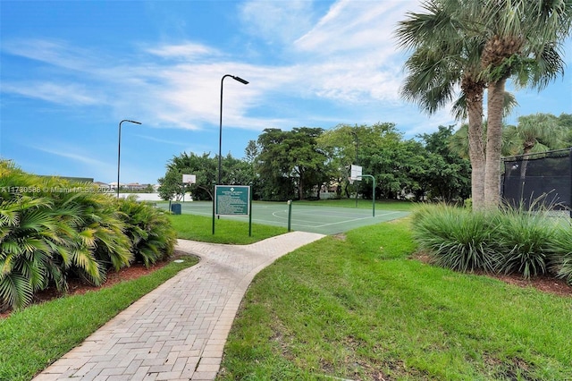 view of community featuring basketball court and a lawn