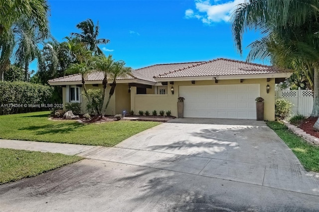 view of front of home with a garage and a front lawn