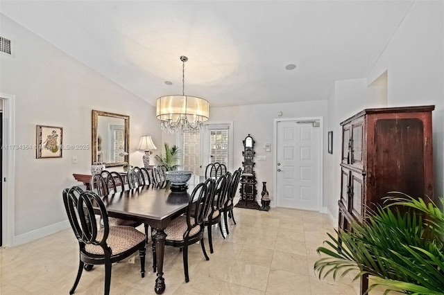 tiled dining space with vaulted ceiling and a chandelier