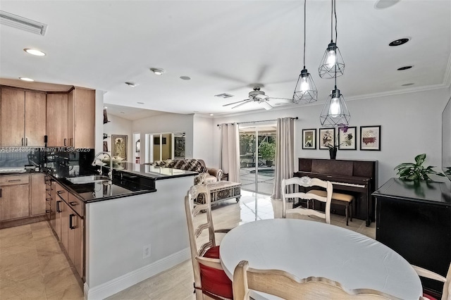 kitchen featuring sink, ceiling fan, backsplash, decorative light fixtures, and kitchen peninsula