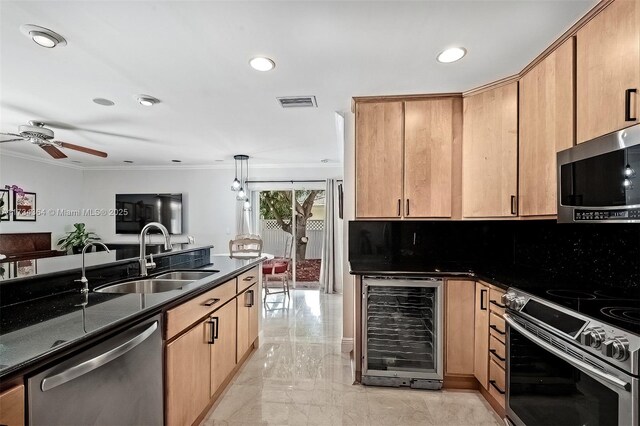 kitchen with sink, dark stone countertops, hanging light fixtures, stainless steel appliances, and beverage cooler