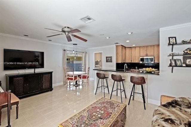 kitchen featuring pendant lighting, ornamental molding, a kitchen bar, decorative backsplash, and kitchen peninsula