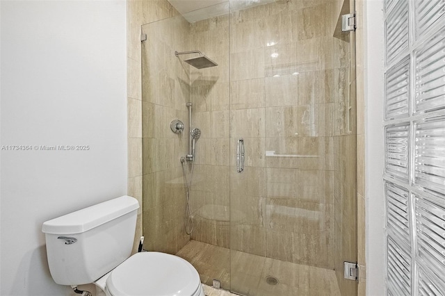 bathroom with a shower with shower door and toilet