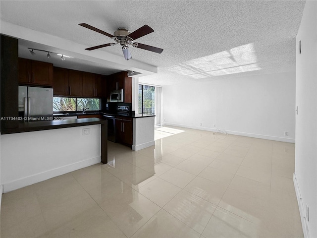 kitchen featuring dark brown cabinetry, sink, a textured ceiling, appliances with stainless steel finishes, and ceiling fan