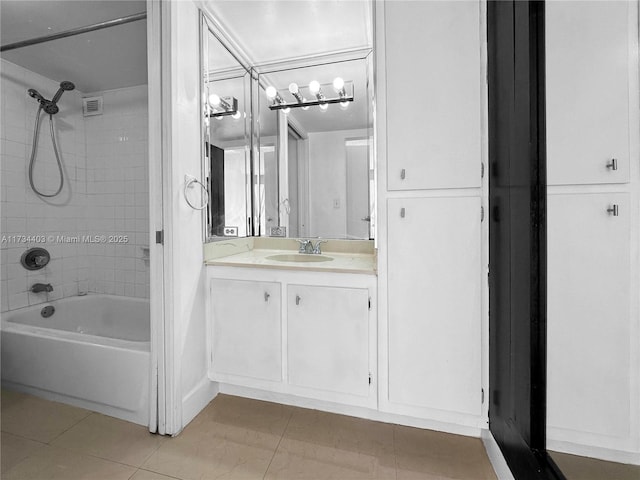 bathroom with tile patterned flooring, vanity, and tiled shower / bath combo