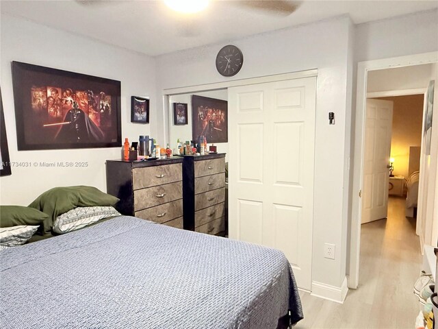 bedroom featuring ceiling fan, light hardwood / wood-style floors, and a closet