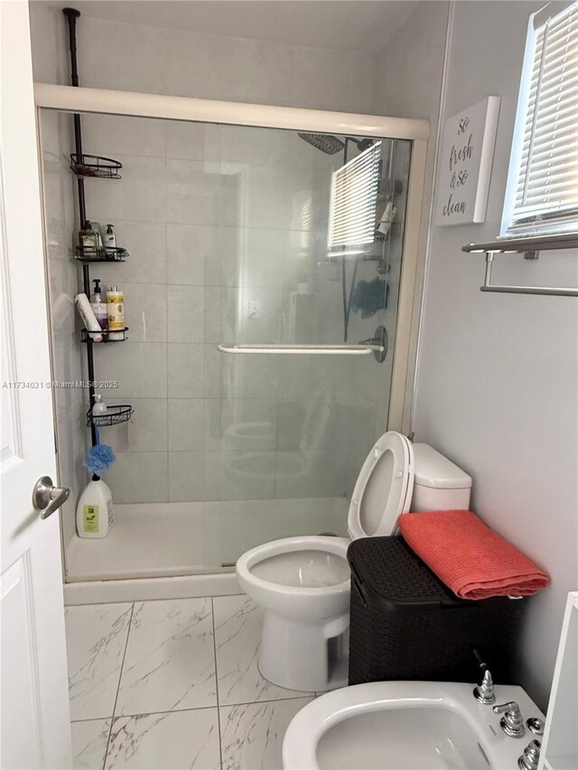 bathroom with a bidet, toilet, an enclosed shower, and sink