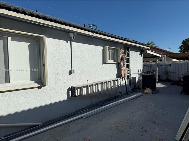 view of side of property with central AC unit and a patio