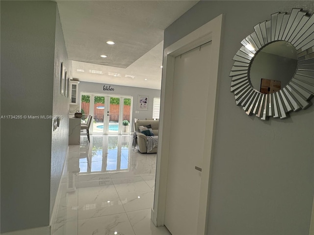 hallway featuring recessed lighting, french doors, and marble finish floor