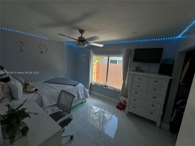 bedroom with baseboards, marble finish floor, a textured ceiling, and a ceiling fan