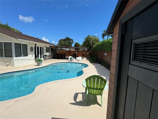 view of pool featuring a patio area, a fenced in pool, french doors, and a fenced backyard