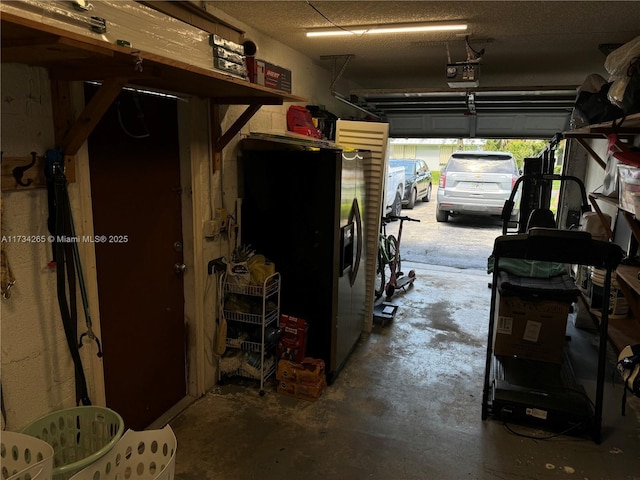 garage featuring a garage door opener and stainless steel fridge with ice dispenser