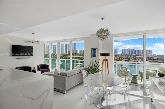 living room with light tile patterned floors, a wall of windows, a chandelier, and a water view