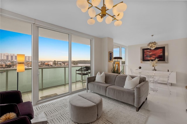 living room with a notable chandelier, light tile patterned floors, expansive windows, and a water view