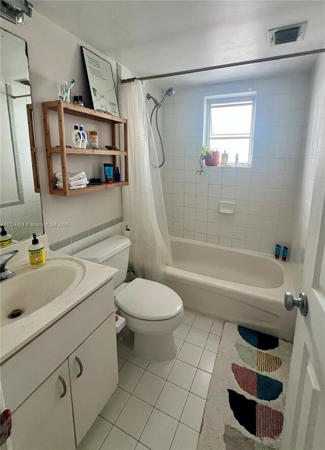 full bathroom featuring vanity, shower / bath combination with curtain, tile patterned floors, and toilet