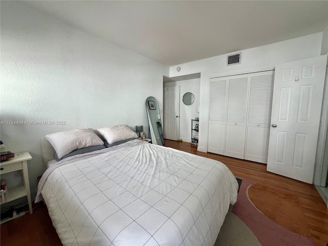 bedroom with dark wood-type flooring and a closet