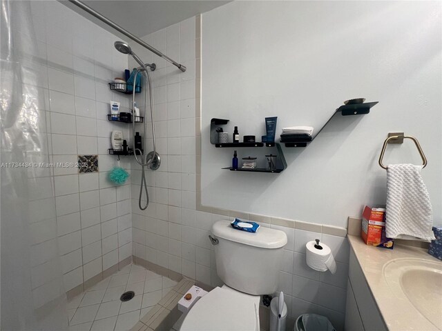 bathroom with walk in shower, toilet, sink, and tile walls