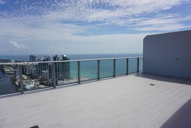 view of patio with a water view and a balcony