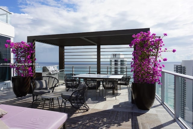 view of patio / terrace featuring a grill, a balcony, and a water view