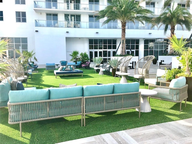 view of property's community featuring outdoor lounge area and a lawn