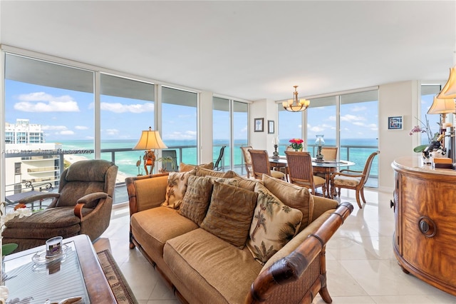 living room with a water view, expansive windows, an inviting chandelier, and light tile patterned floors