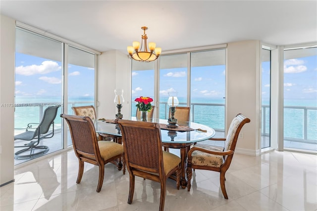 dining room with expansive windows, light tile patterned flooring, a water view, and an inviting chandelier