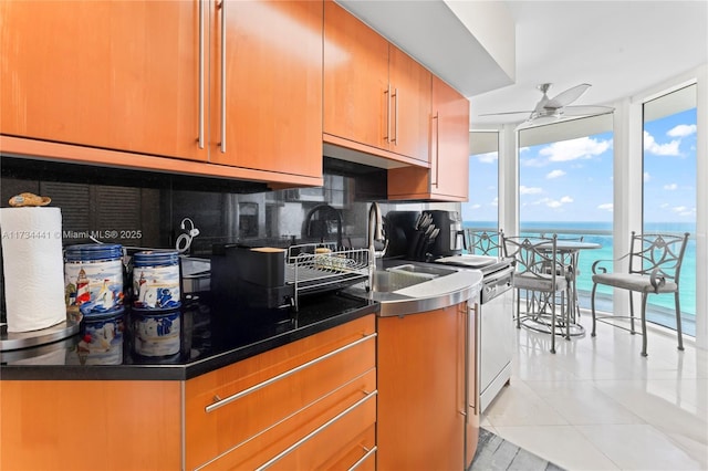 6365 Collins Ave Unit 1901, Miami Beach, FL 33141 - kitchen with ceiling fan, light tile patterned floors, backsplash, expansive windows, and a water view