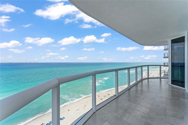 balcony with a water view and a beach view