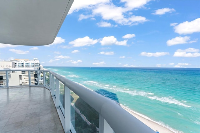 balcony featuring a beach view and a water view