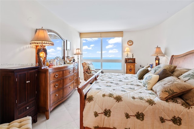 bedroom with light tile patterned flooring and a water view