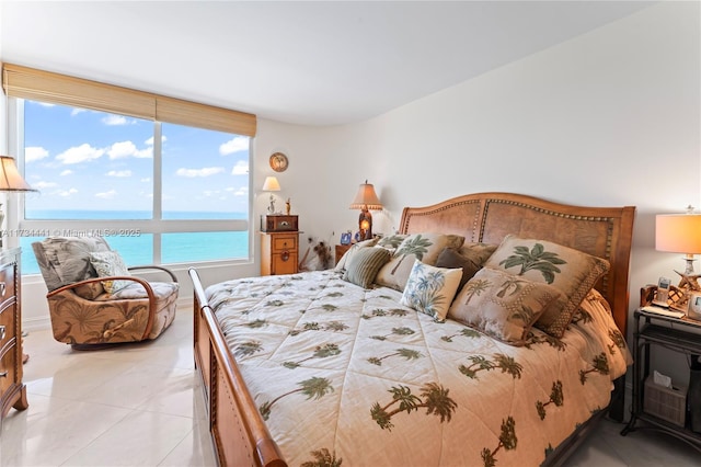 bedroom featuring a water view and light tile patterned floors