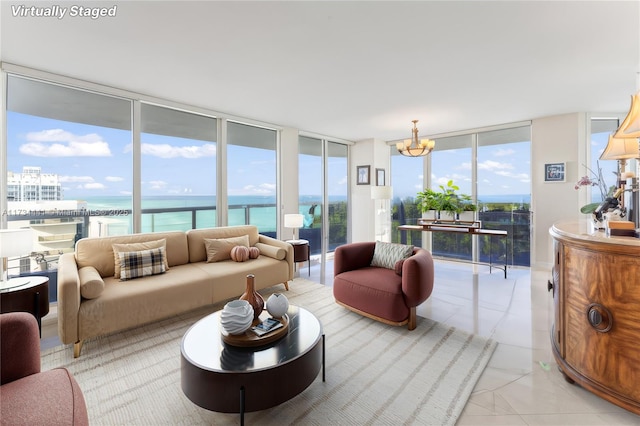 living room with floor to ceiling windows, a water view, plenty of natural light, and an inviting chandelier