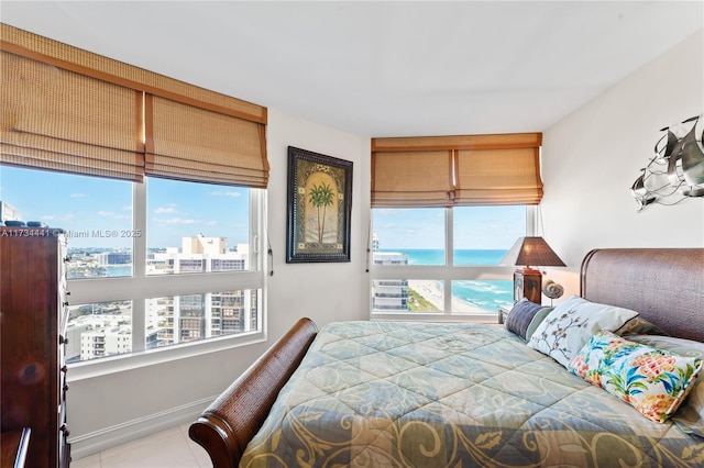 bedroom with a water view and light tile patterned floors