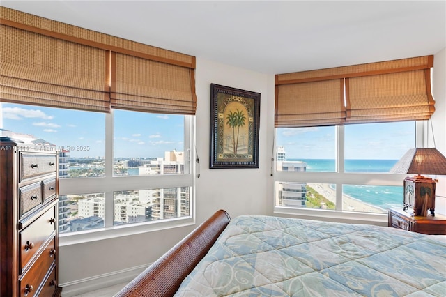 bedroom with a water view and a beach view