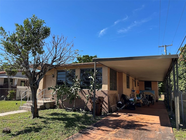 manufactured / mobile home with a carport and a front lawn