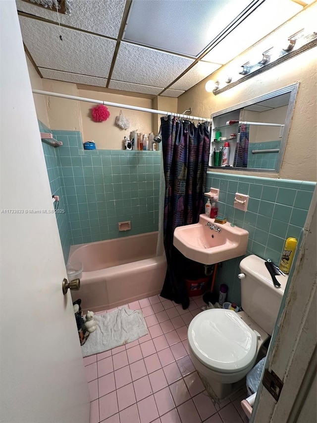 full bathroom featuring tile patterned floors, toilet, sink, tile walls, and shower / bath combo