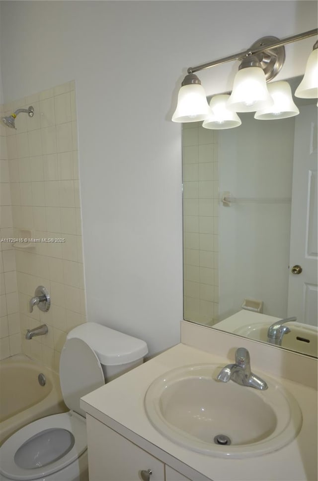 full bathroom with tiled shower / bath combo, vanity, and toilet