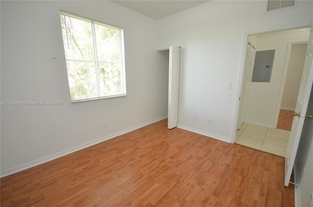 unfurnished bedroom featuring electric panel and light wood-type flooring