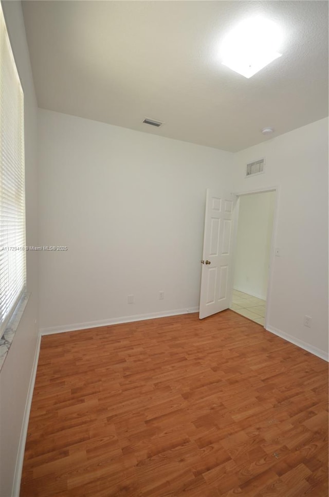 unfurnished room with hardwood / wood-style floors