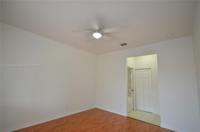 spare room with ceiling fan and light wood-type flooring