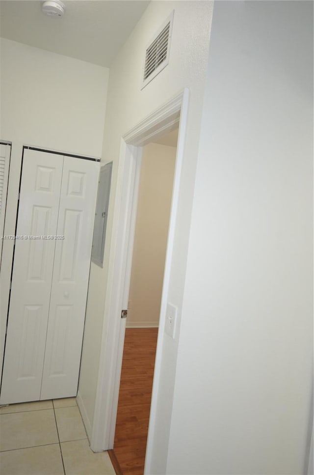 hallway featuring light tile patterned floors and electric panel