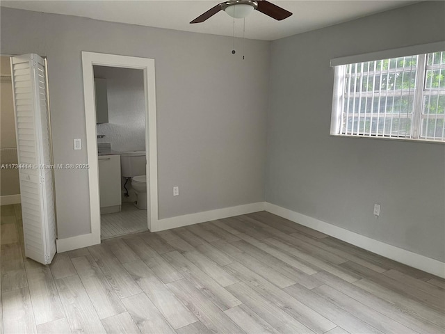 unfurnished bedroom with light wood-type flooring, connected bathroom, and ceiling fan