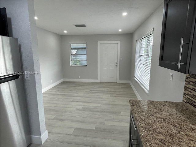 kitchen with plenty of natural light, stainless steel fridge, and light hardwood / wood-style floors