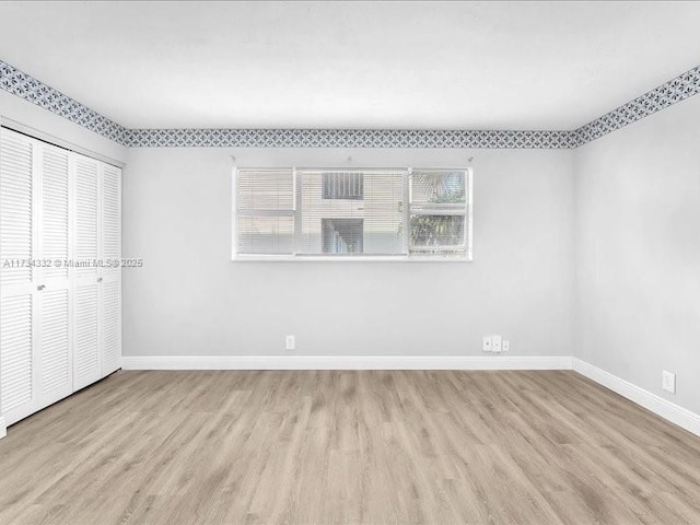 unfurnished bedroom featuring light hardwood / wood-style floors and a closet