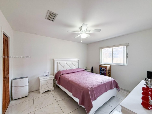 bedroom with ceiling fan, a closet, and light tile patterned floors