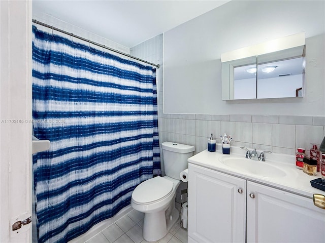 bathroom with walk in shower, toilet, tile walls, vanity, and tile patterned flooring