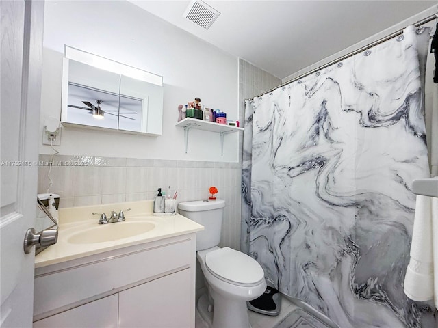 bathroom featuring tile walls, vanity, curtained shower, and toilet