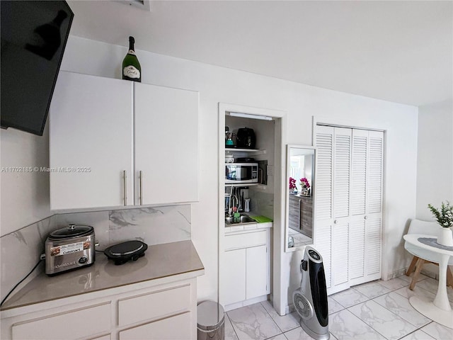 kitchen featuring white cabinetry and sink