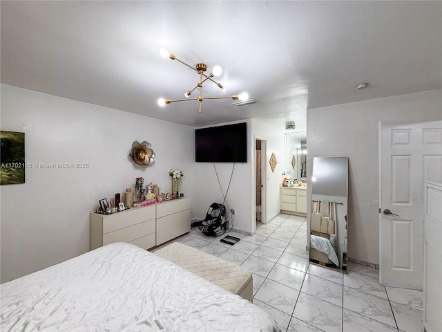 bedroom with an inviting chandelier and connected bathroom